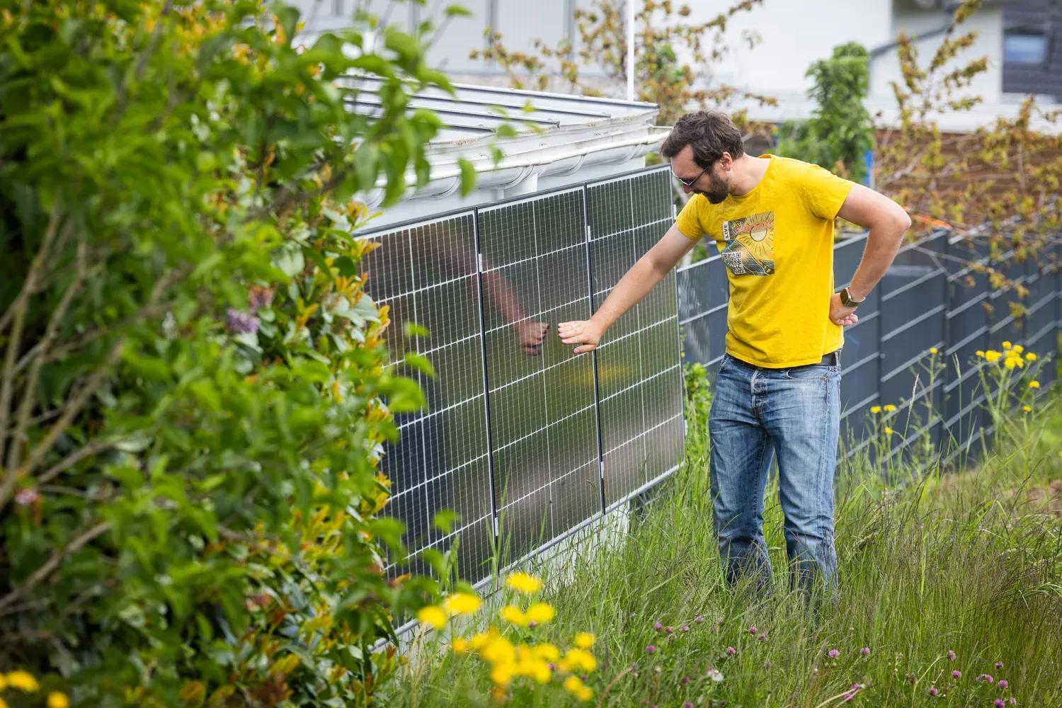 Jörg an den PV-Modulen an der Carportwand