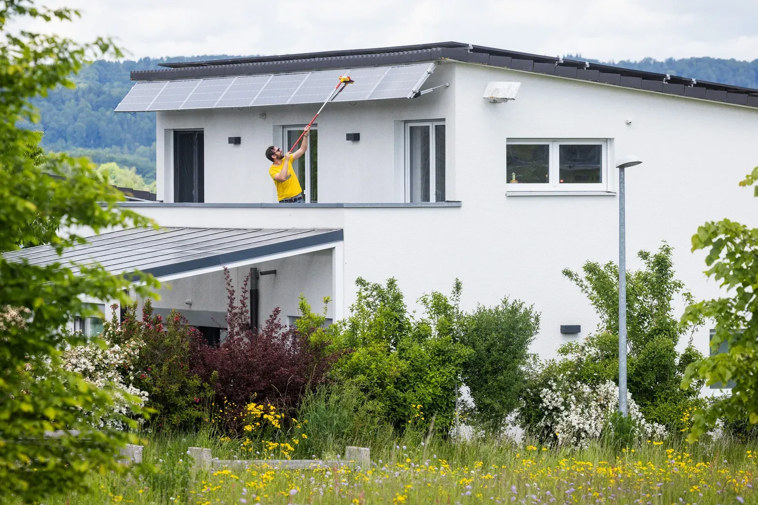 Jörg putzt die PV-Module über dem Balkon