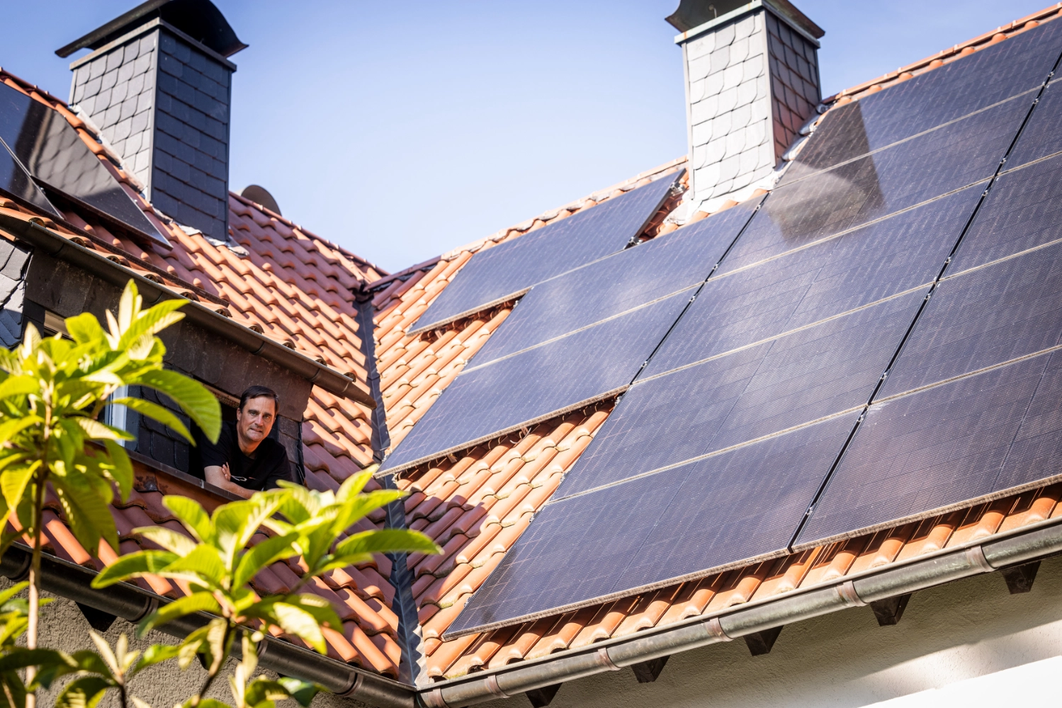 Olaf im Dachfenster mit PV-Anlage