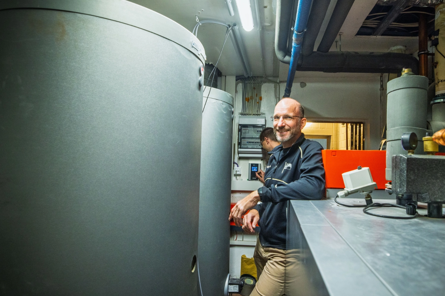 Michael im Technikraum mit Warmwasserspeicher