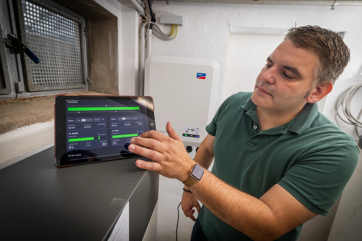Alex showing evcc on tablet in front of inverter