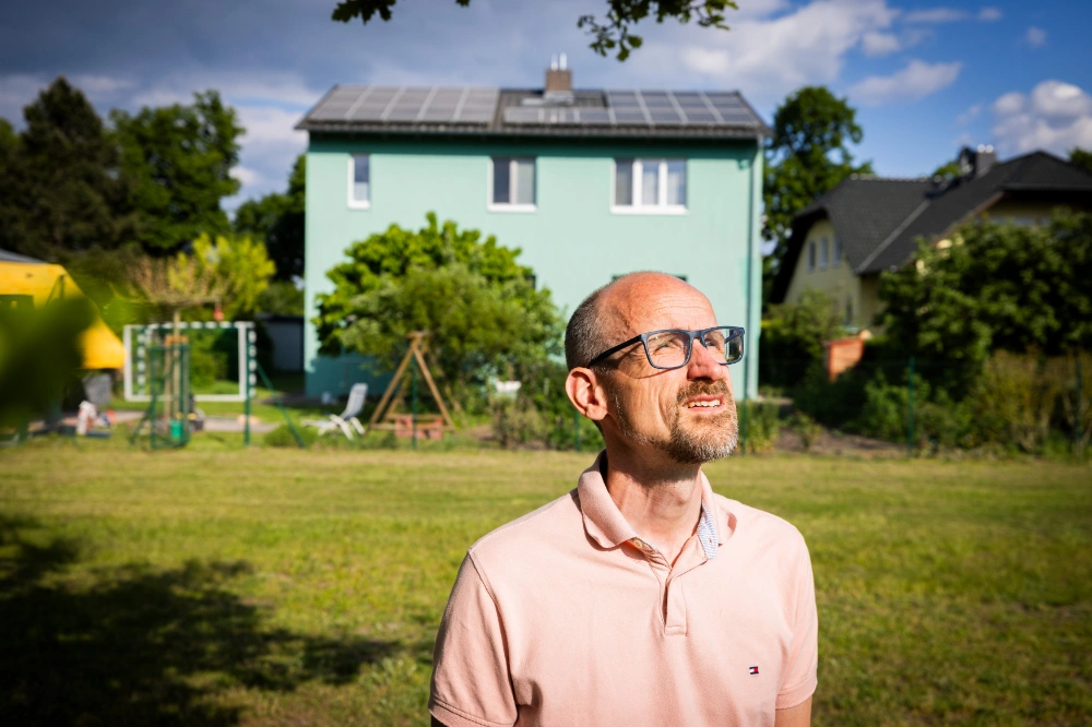 Christian in front of his house with a PV system