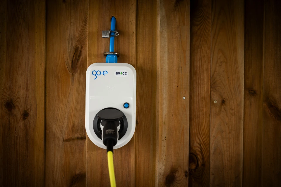 go-e charger on a wooden wall with evcc sticker